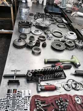 Tools and vehicle parts spread out on a table representing the services of truck transmission shop Best Transmission in Jacksonville, FL